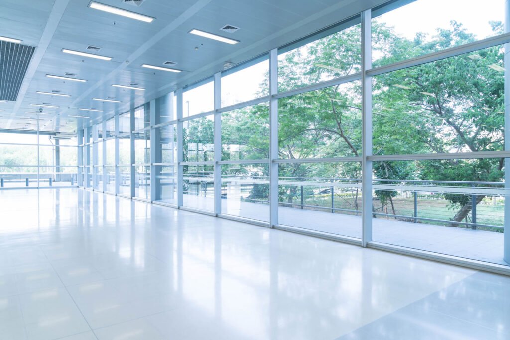 blurred abstract background interior view looking out toward empty office lobby entrance doors glass curtain wall with frame